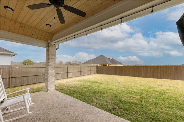 view of yard featuring a fenced backyard, a patio area, and a ceiling fan