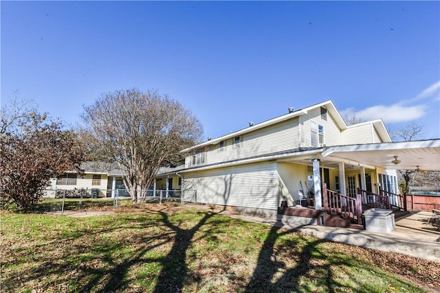 view of side of home with a yard and a porch