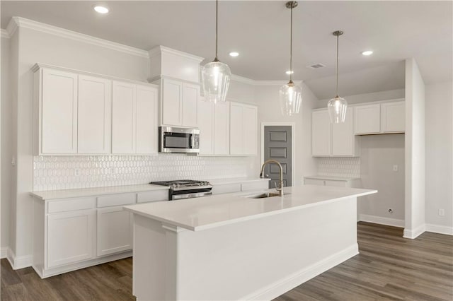 kitchen featuring white cabinets, appliances with stainless steel finishes, a center island with sink, and sink