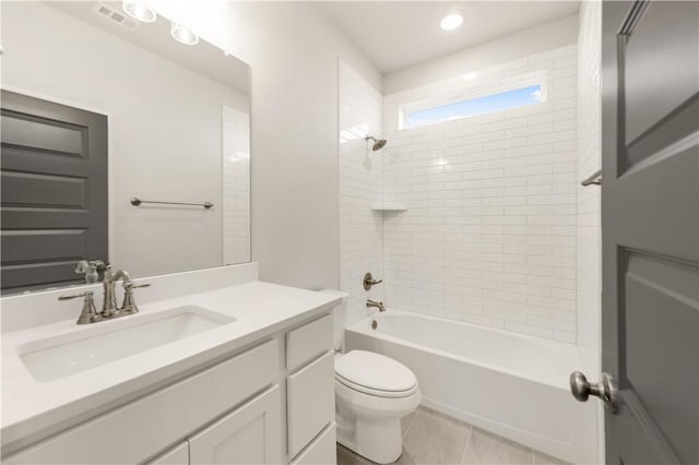 full bathroom with tile patterned flooring, vanity, tiled shower / bath combo, and toilet