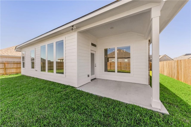 rear view of house featuring a yard and a patio