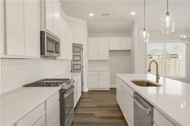 kitchen with white cabinetry, sink, decorative light fixtures, and appliances with stainless steel finishes