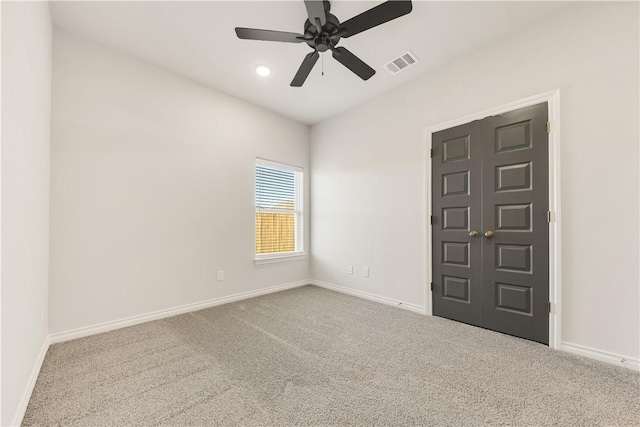 carpeted spare room featuring ceiling fan