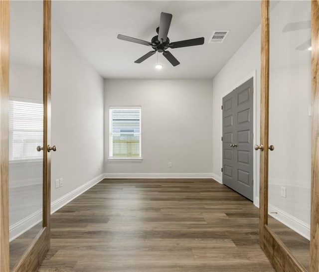 empty room with dark hardwood / wood-style floors and ceiling fan