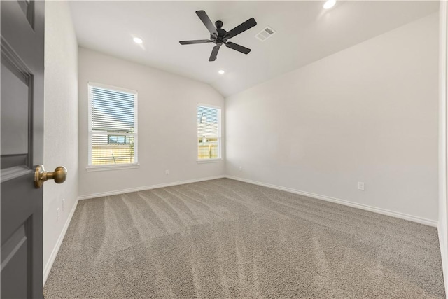 carpeted spare room with ceiling fan and vaulted ceiling