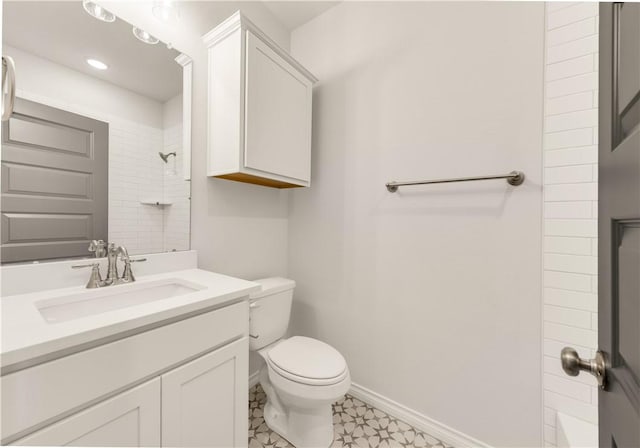 bathroom with vanity, toilet, and a tile shower