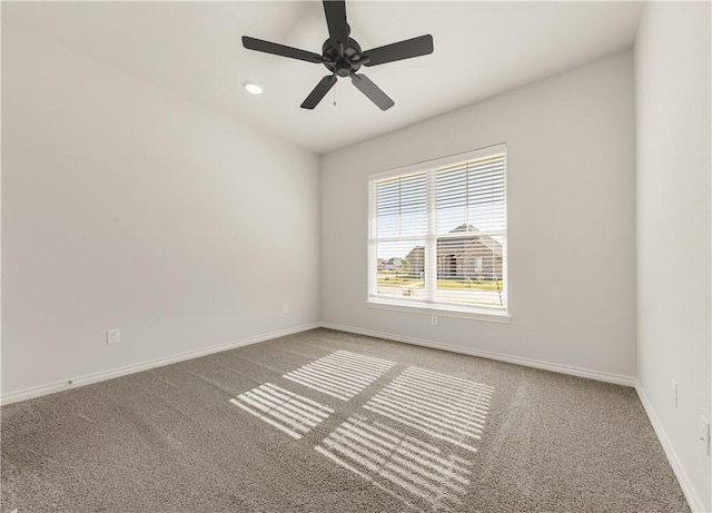 carpeted spare room featuring ceiling fan