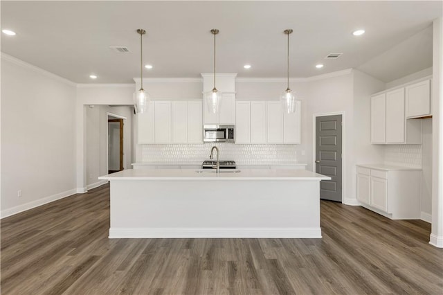 kitchen featuring stainless steel appliances, a kitchen island with sink, and dark wood-type flooring