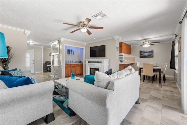 living room featuring ornamental molding, a textured ceiling, and ceiling fan