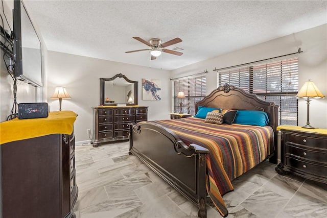 bedroom with ceiling fan and a textured ceiling