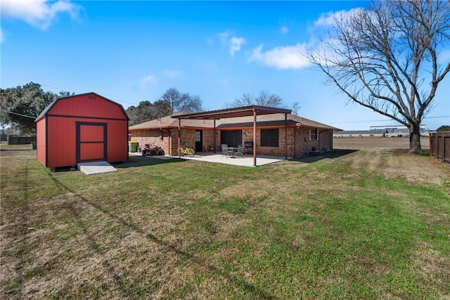 back of property featuring a shed, a lawn, and a patio