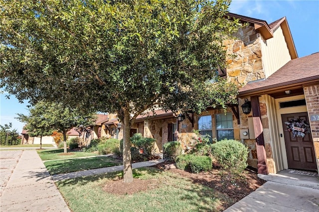 view of property hidden behind natural elements featuring a front lawn