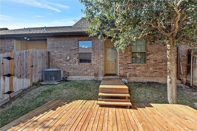 exterior space with a wooden deck, cooling unit, and a front lawn