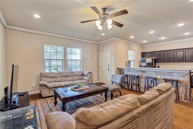 living room with ceiling fan and crown molding