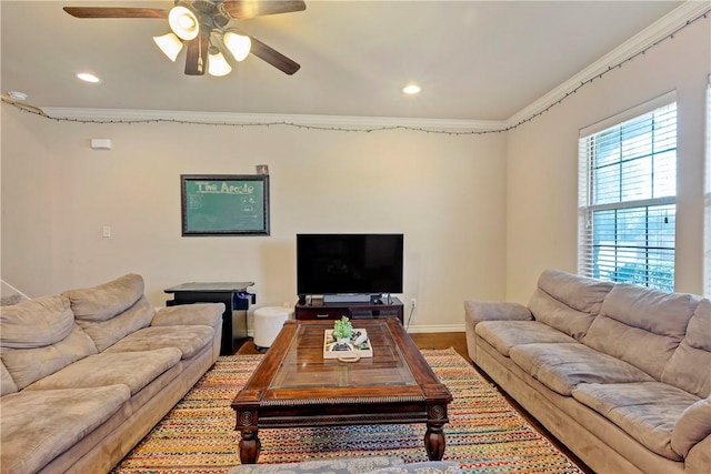 living room with hardwood / wood-style flooring, ceiling fan, and crown molding