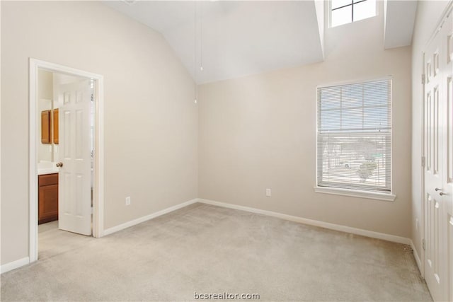 carpeted empty room with lofted ceiling