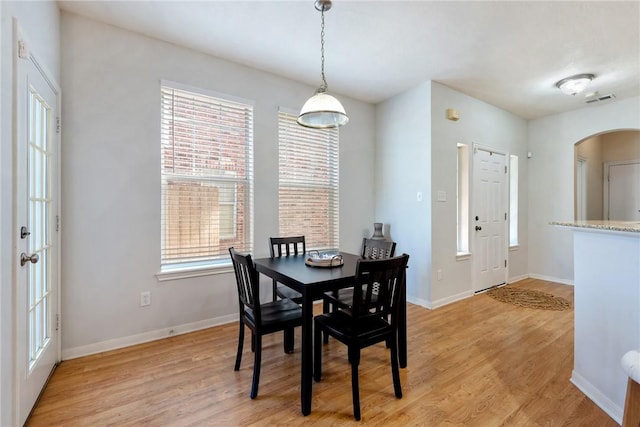 dining room with light hardwood / wood-style flooring and a healthy amount of sunlight