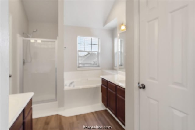 bathroom featuring wood-type flooring, vanity, separate shower and tub, and lofted ceiling