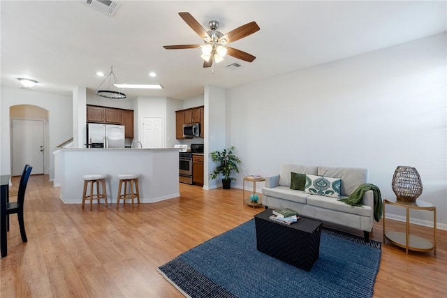 living room featuring ceiling fan and light wood-type flooring