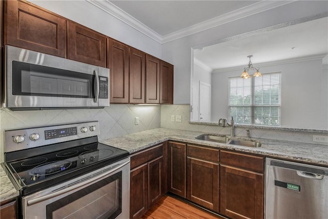 801 Luther St W Unit 106, College Station, TX 77840 - kitchen featuring appliances with stainless steel finishes, a chandelier, light stone countertops, decorative backsplash, and light wood-type flooring