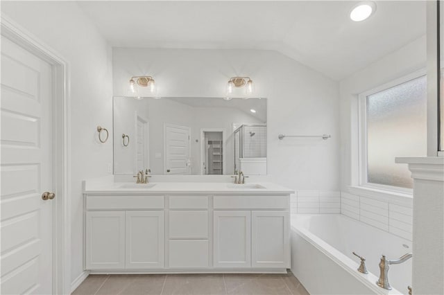 bathroom with tile patterned flooring, lofted ceiling, vanity, and plus walk in shower