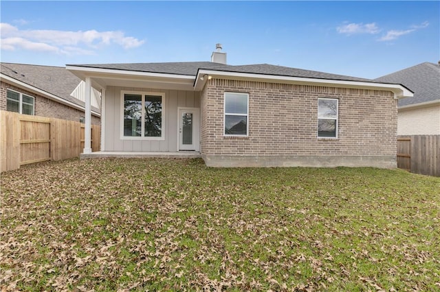 3702 Archer Falls Ct, College Station, TX 77845 - rear view of house with board and batten siding, a chimney, a fenced backyard, and brick siding