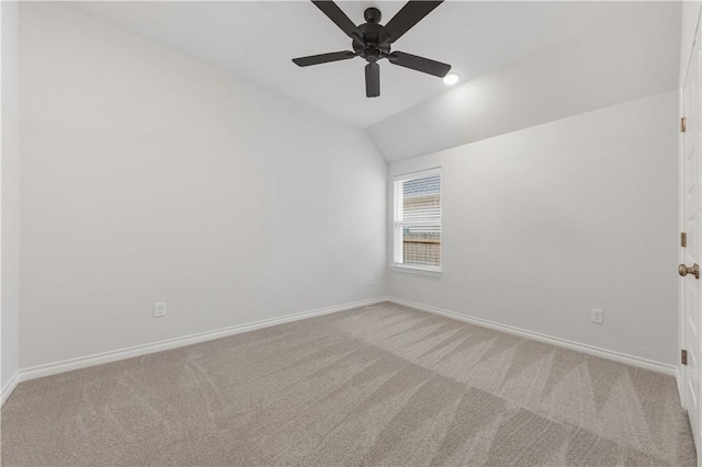 empty room featuring ceiling fan, carpet, and vaulted ceiling