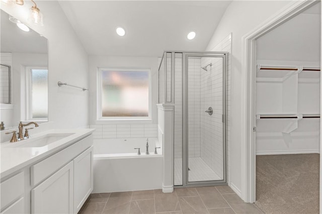 bathroom with tile patterned flooring, shower with separate bathtub, vanity, and vaulted ceiling