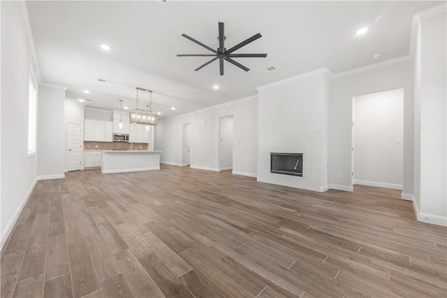 3702 Archer Falls Ct, College Station, TX 77845 - unfurnished living room featuring a ceiling fan, ornamental molding, light wood finished floors, recessed lighting, and a fireplace