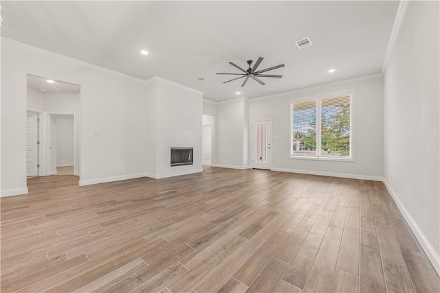 unfurnished living room featuring ceiling fan, a fireplace, ornamental molding, and light wood-type flooring