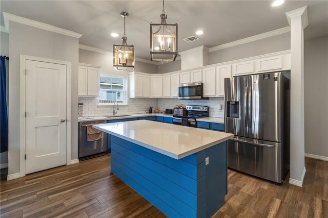 kitchen featuring appliances with stainless steel finishes, dark hardwood / wood-style flooring, white cabinetry, and a kitchen island