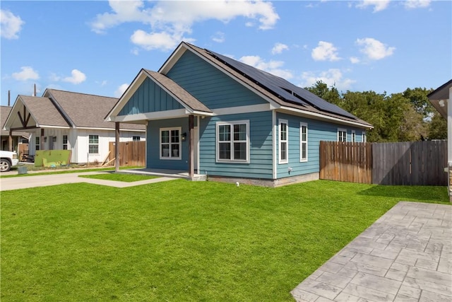 view of front of home featuring a front yard and solar panels