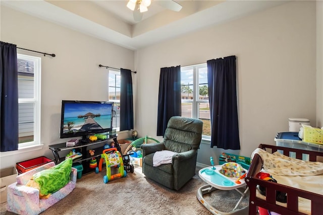 rec room featuring ceiling fan and a tray ceiling