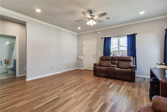 living room with ceiling fan, ornamental molding, and light wood-type flooring