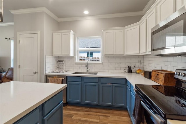 kitchen featuring blue cabinetry, electric range, hardwood / wood-style flooring, and sink