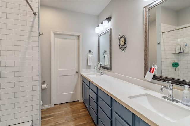 bathroom featuring a tile shower, vanity, and hardwood / wood-style flooring