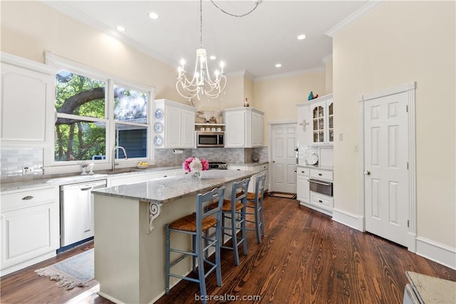 kitchen with white cabinetry, a center island, dark wood-type flooring, light stone counters, and appliances with stainless steel finishes