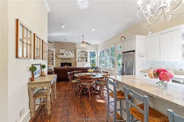 kitchen with light stone countertops, dark hardwood / wood-style floors, stainless steel fridge, decorative backsplash, and white cabinets