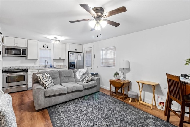 living room featuring dark hardwood / wood-style floors, ceiling fan, and sink