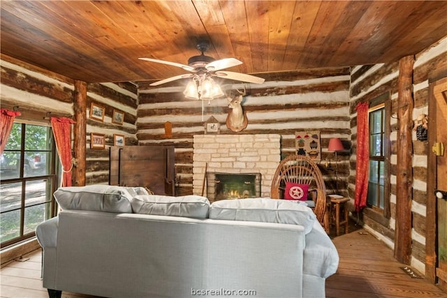 living room with a healthy amount of sunlight, light hardwood / wood-style floors, and rustic walls