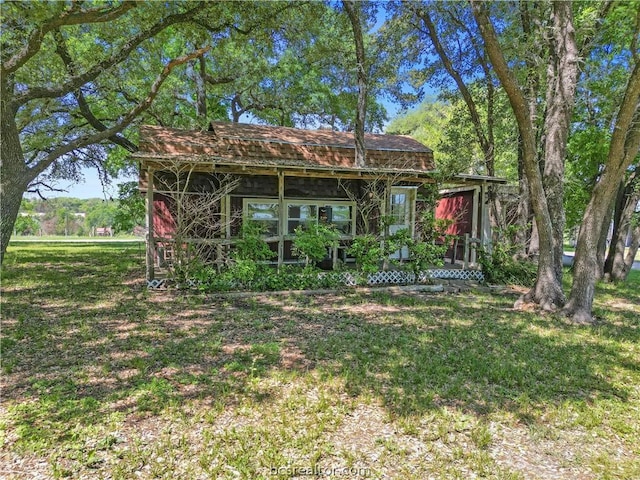 rear view of property featuring a lawn