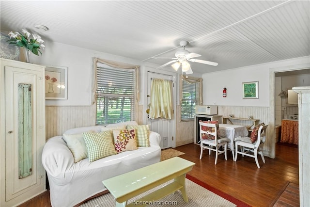 living room featuring wood walls, dark hardwood / wood-style floors, and ceiling fan