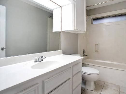 full bathroom featuring tile patterned floors, vanity, toilet, and shower / washtub combination