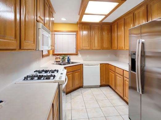 kitchen featuring white appliances, sink, and light tile patterned floors