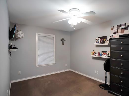 bedroom with dark carpet and ceiling fan