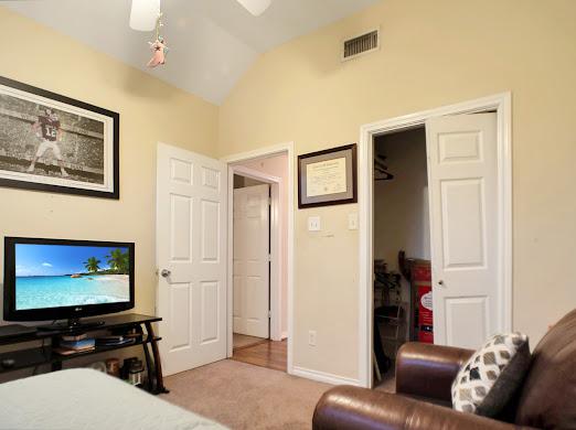 bedroom with ceiling fan, a closet, light colored carpet, and lofted ceiling