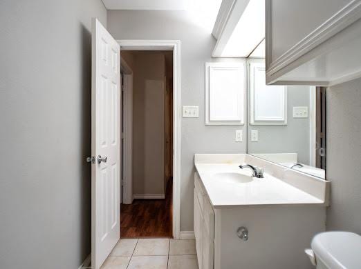 bathroom with tile patterned flooring, vanity, and toilet