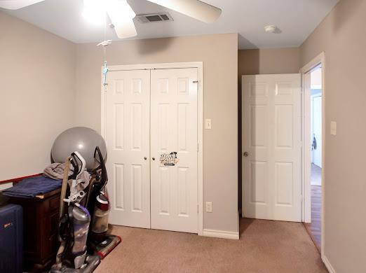 interior space with light carpet and ceiling fan