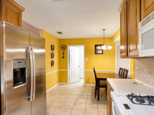 kitchen with light tile patterned floors, hanging light fixtures, white appliances, and an inviting chandelier