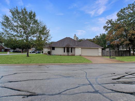 single story home featuring a garage and a front lawn